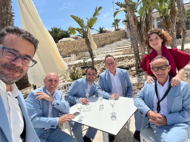 La nostra band di musica ed eventi live durante un momento di relax prima di un'esibizione. Sei musicisti professionisti con eleganza e stile, pronti ad offrire intrattenimento musicale su misura per matrimoni, eventi aziendali, feste private e cerimonie. Un gruppo affiatato e sorridente, immerso in un contesto esclusivo, ideale per trasformare ogni evento in un’esperienza raffinata e indimenticabile all'insegna della musica ed eventi live di qualità